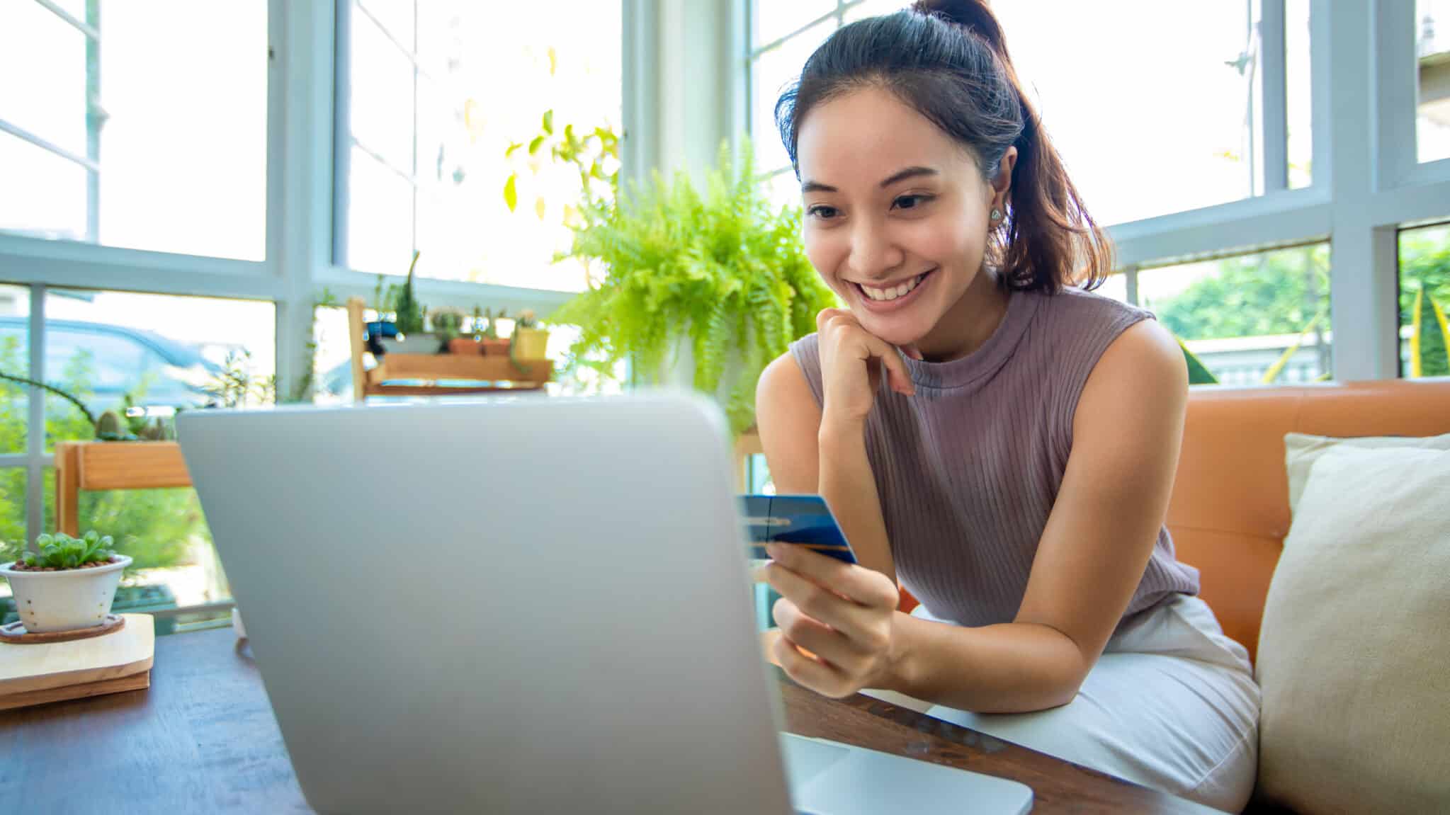 happy young woman using credit card and earning rewards