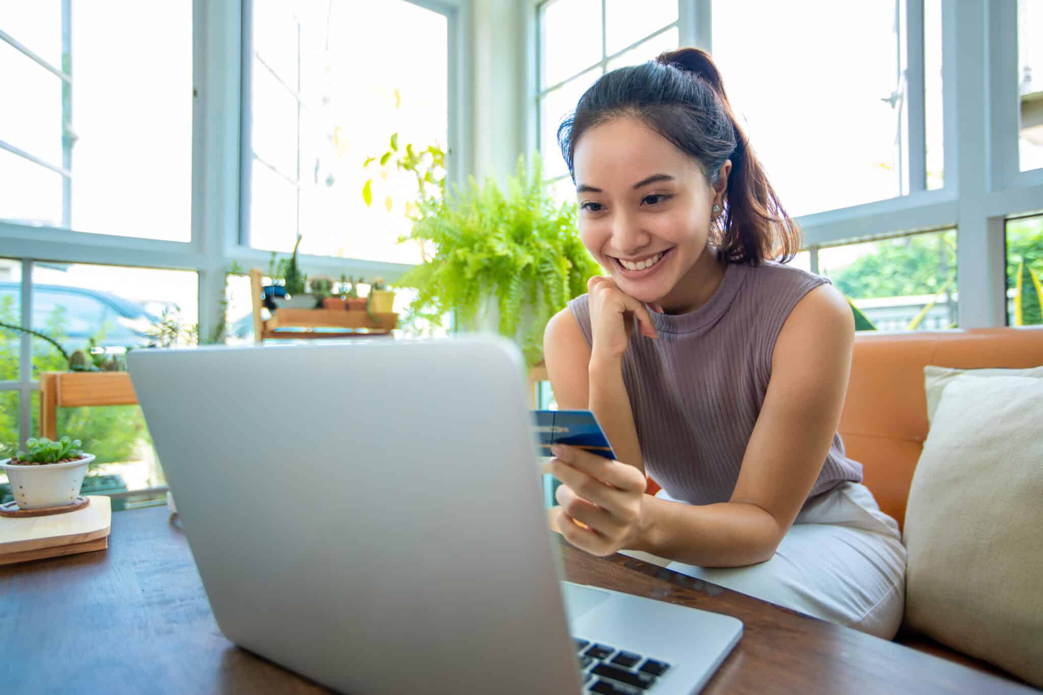 happy young woman using credit card and earning rewards