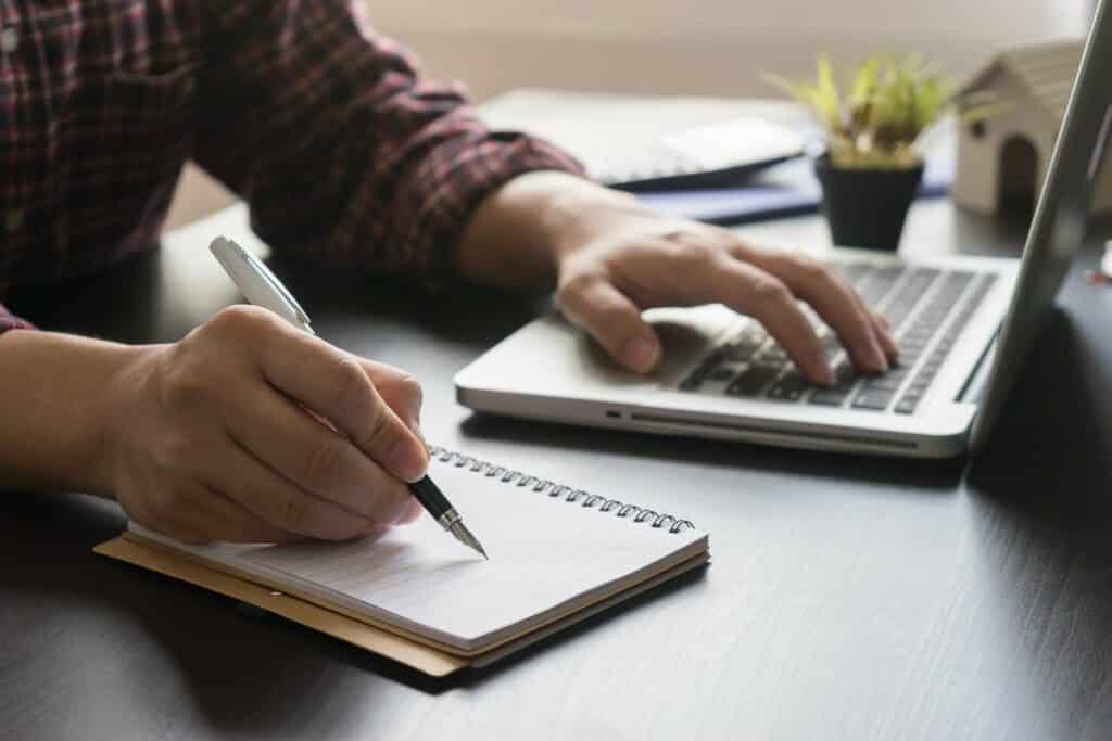 Close up of person working on laptop, improving their credit score