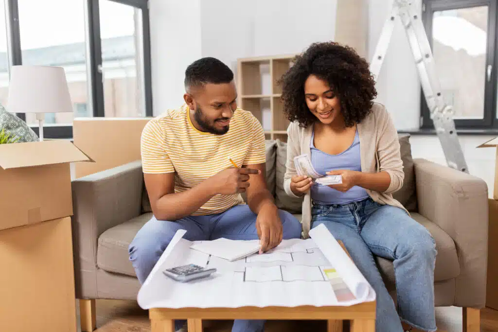 A happy couple working together on their finances, smiling and looking confident about their financial future.