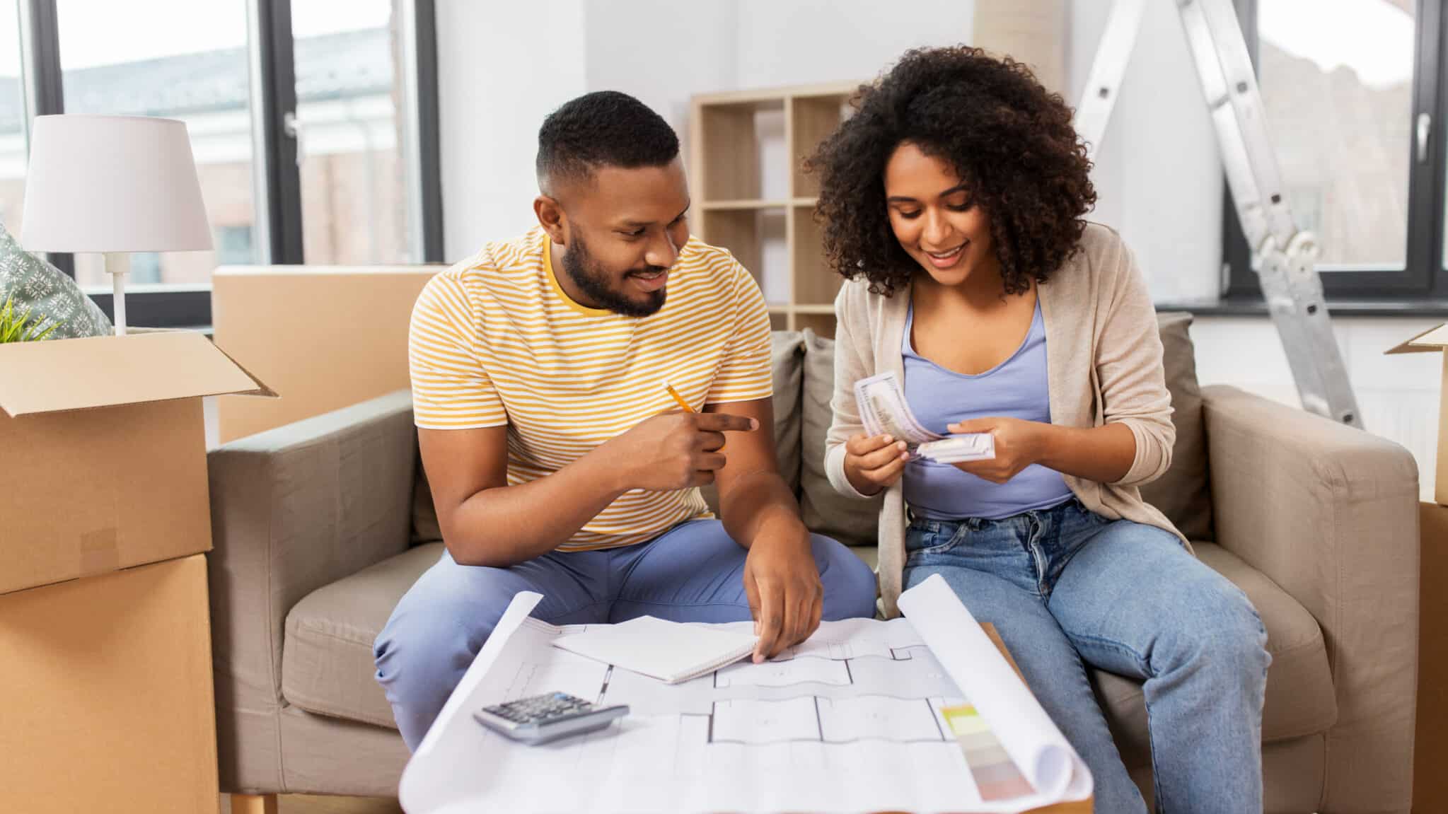 A happy couple working together on their finances, smiling and looking confident about their financial future.