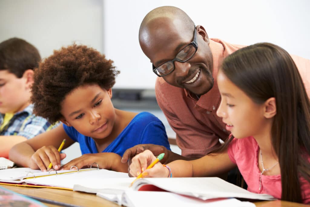 Teacher helping students with personal finance project