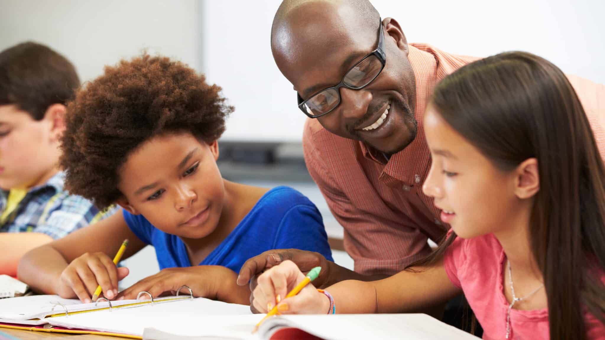 Teacher helping students with personal finance project