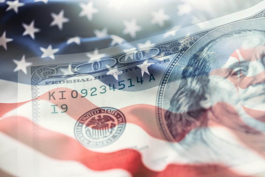 US flag overlaid on a 0 bill, symbolizing debt in America