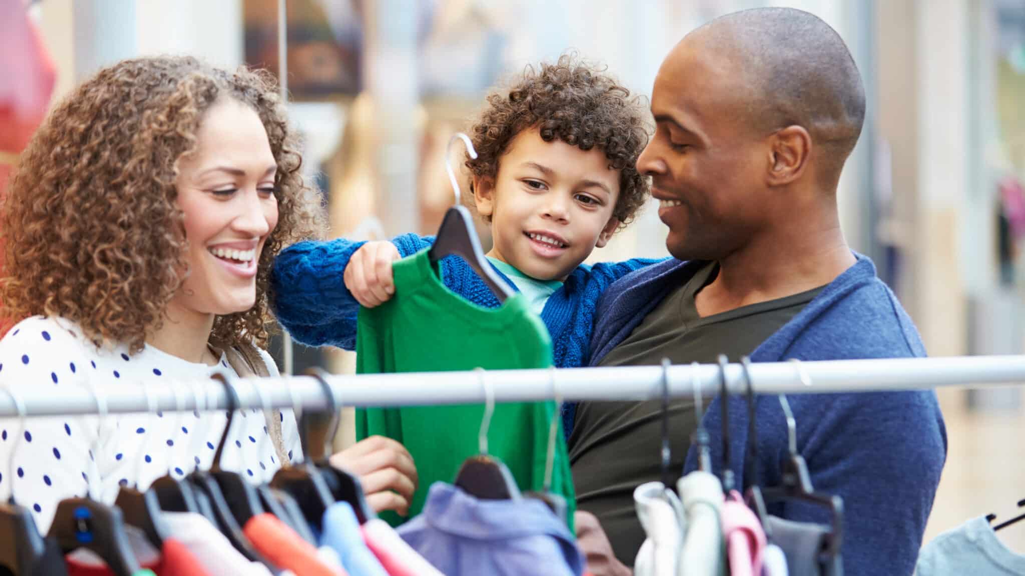 Parents shopping with young child for clothes.