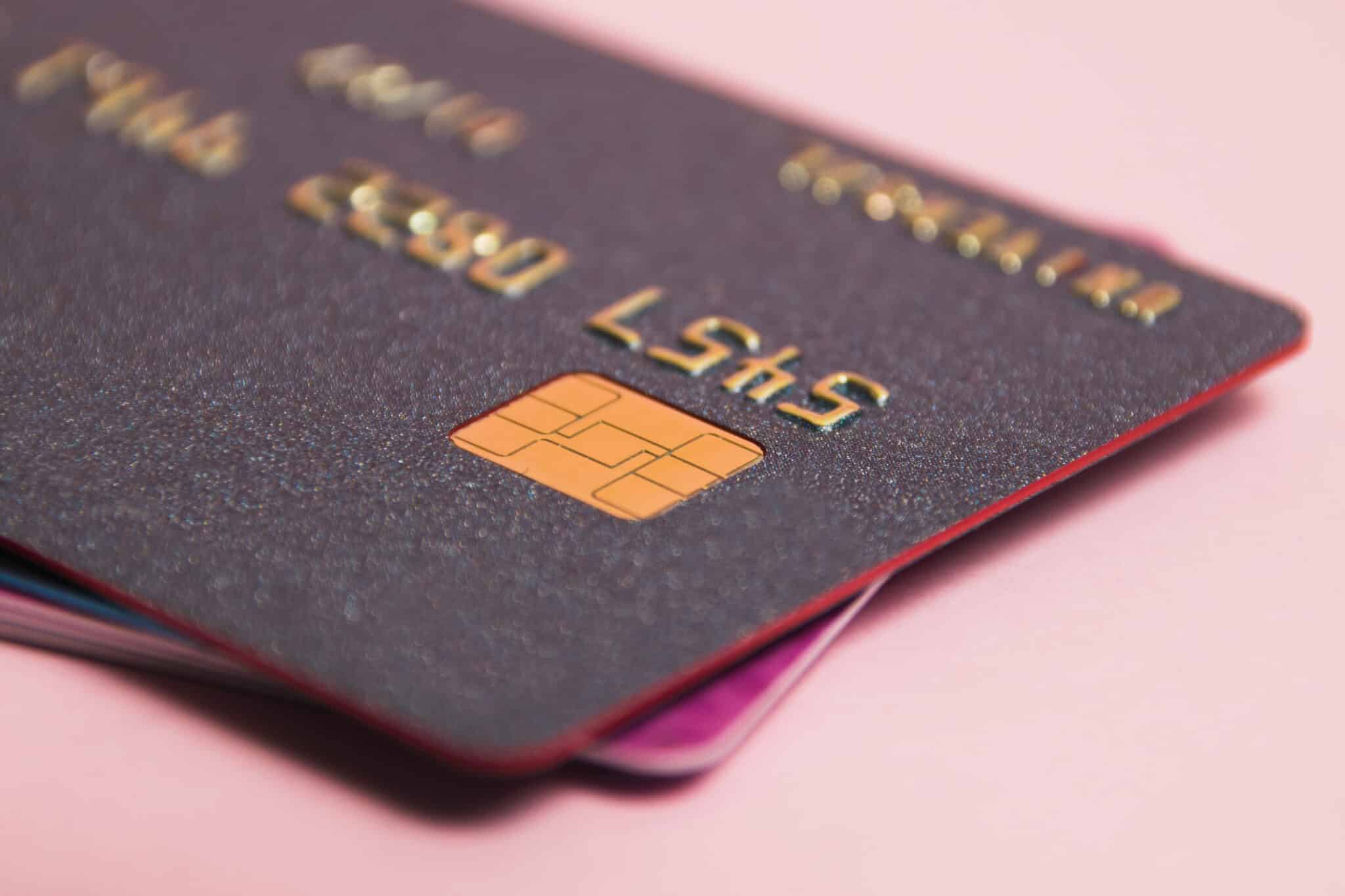 modern bank cards with chips macro, credit cards on a pink background. the concept of bank card payments.