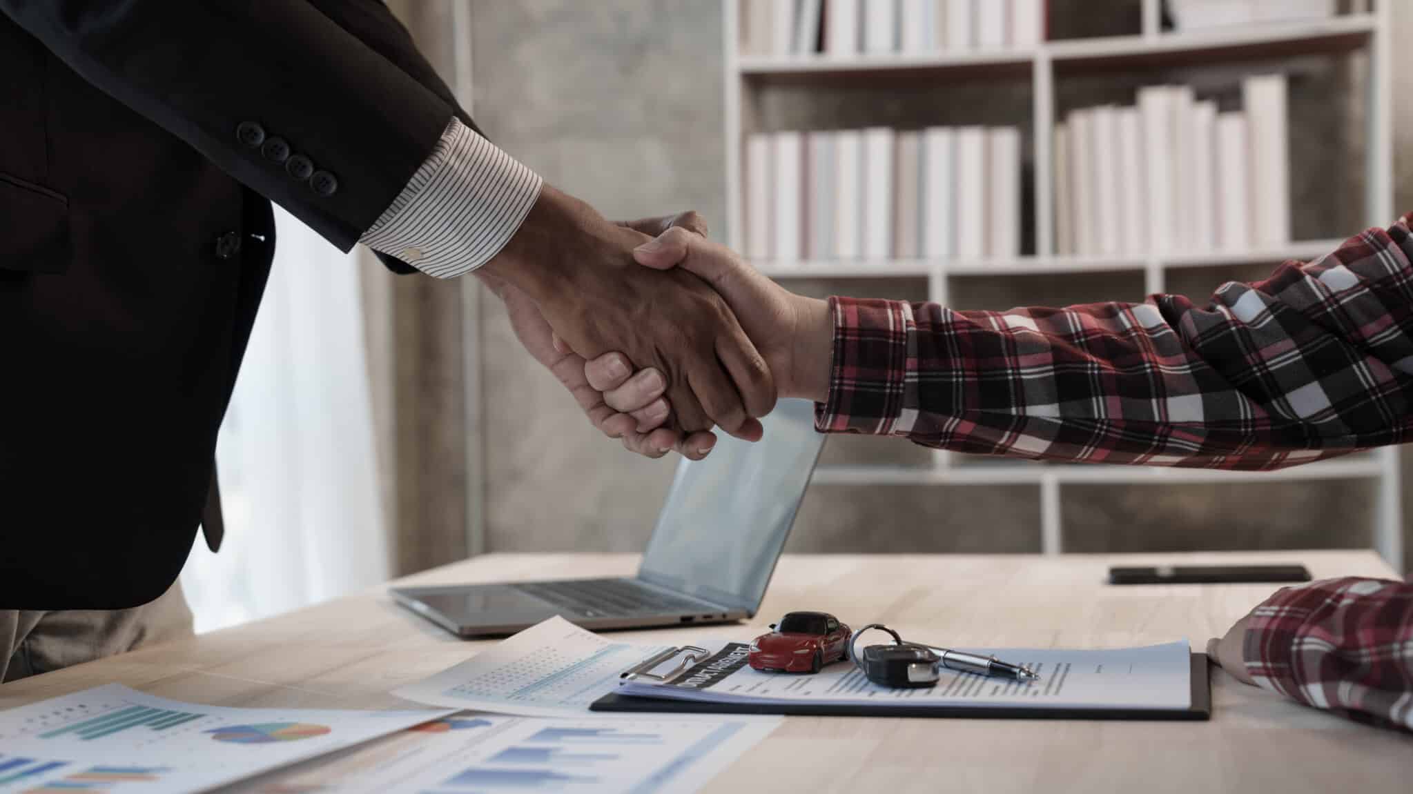 new car loan contract, keys and shaking hands
