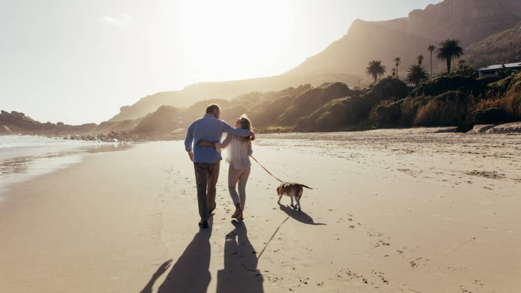 a couple enjoying retirement with a walk on the beach