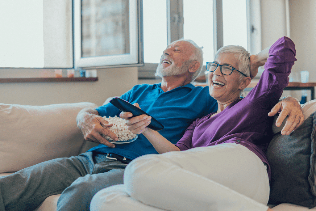 older couple at home watching a movie and having a good time