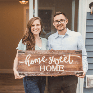 Younger couple standing outside a new home
