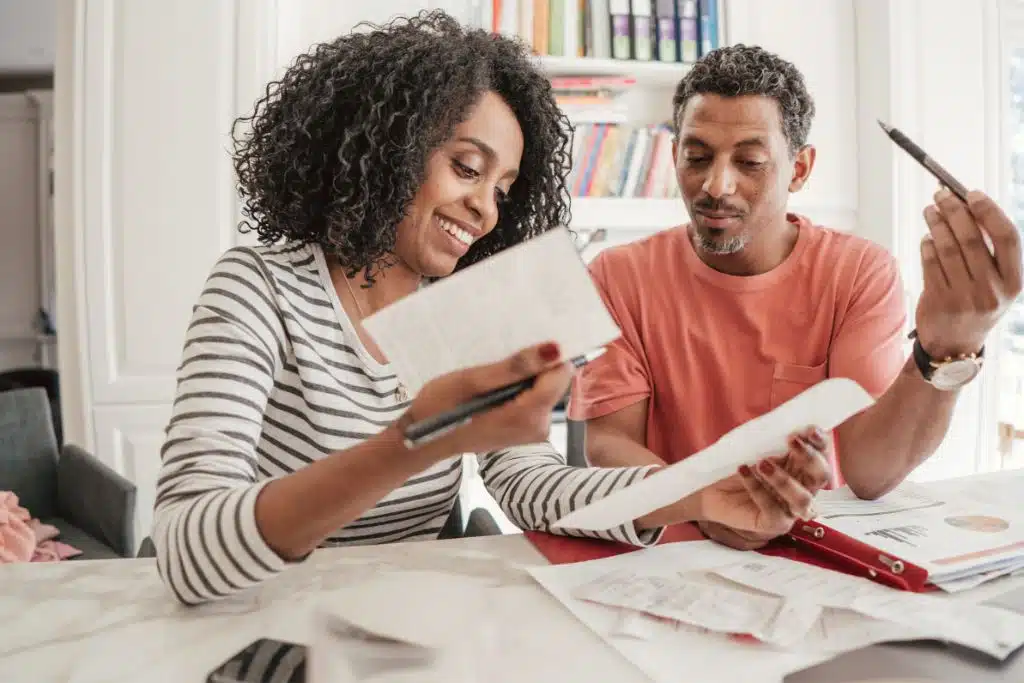 Person creating their first monthly budget on paper and laptop
