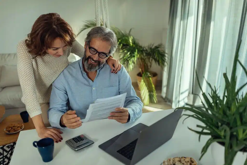 Couple celebrating after reaching their savings goal for a lifetime travel dream