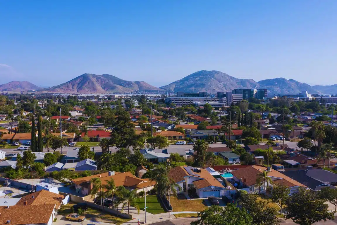 Aerial view of Fontana with suburban homes and the San Gabriel Mountains in the distance.