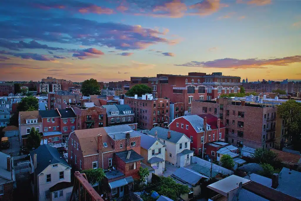 Vibrant Queens street scene with Unisphere globe in Flushing Meadows-Corona Park under a blue sky.