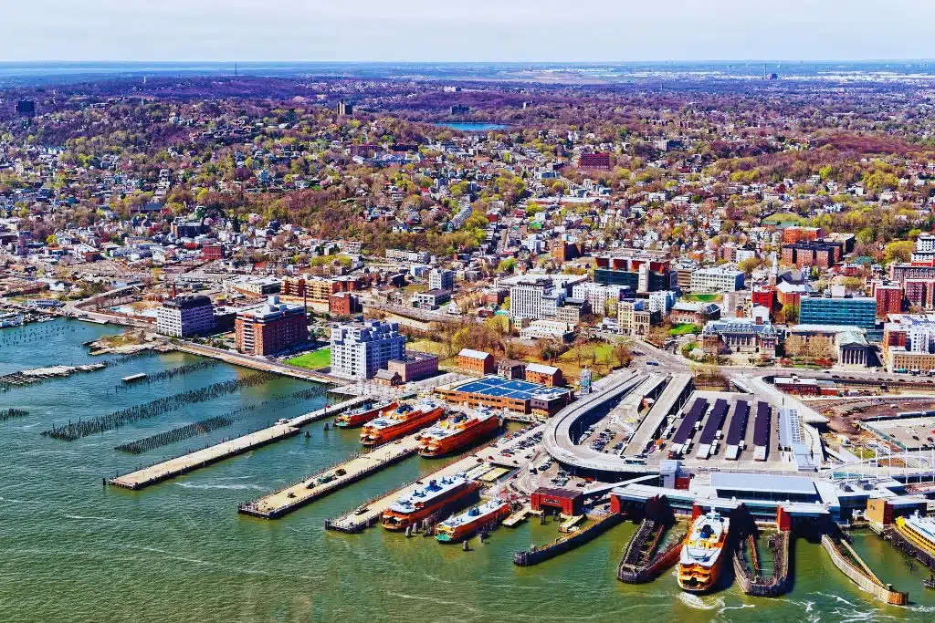 Verrazzano-Narrows Bridge at sunset connecting Staten Island to Brooklyn, with city skyline in the background.