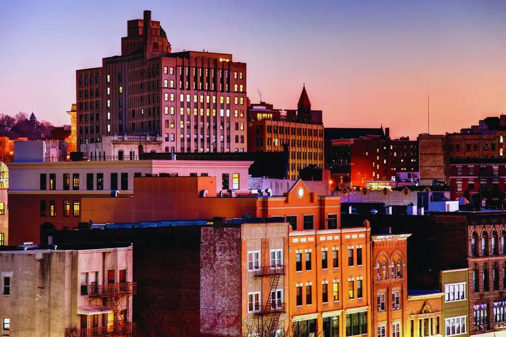 Yonkers waterfront along the Hudson River with the historic downtown and dramatic Palisades cliffs in the background.